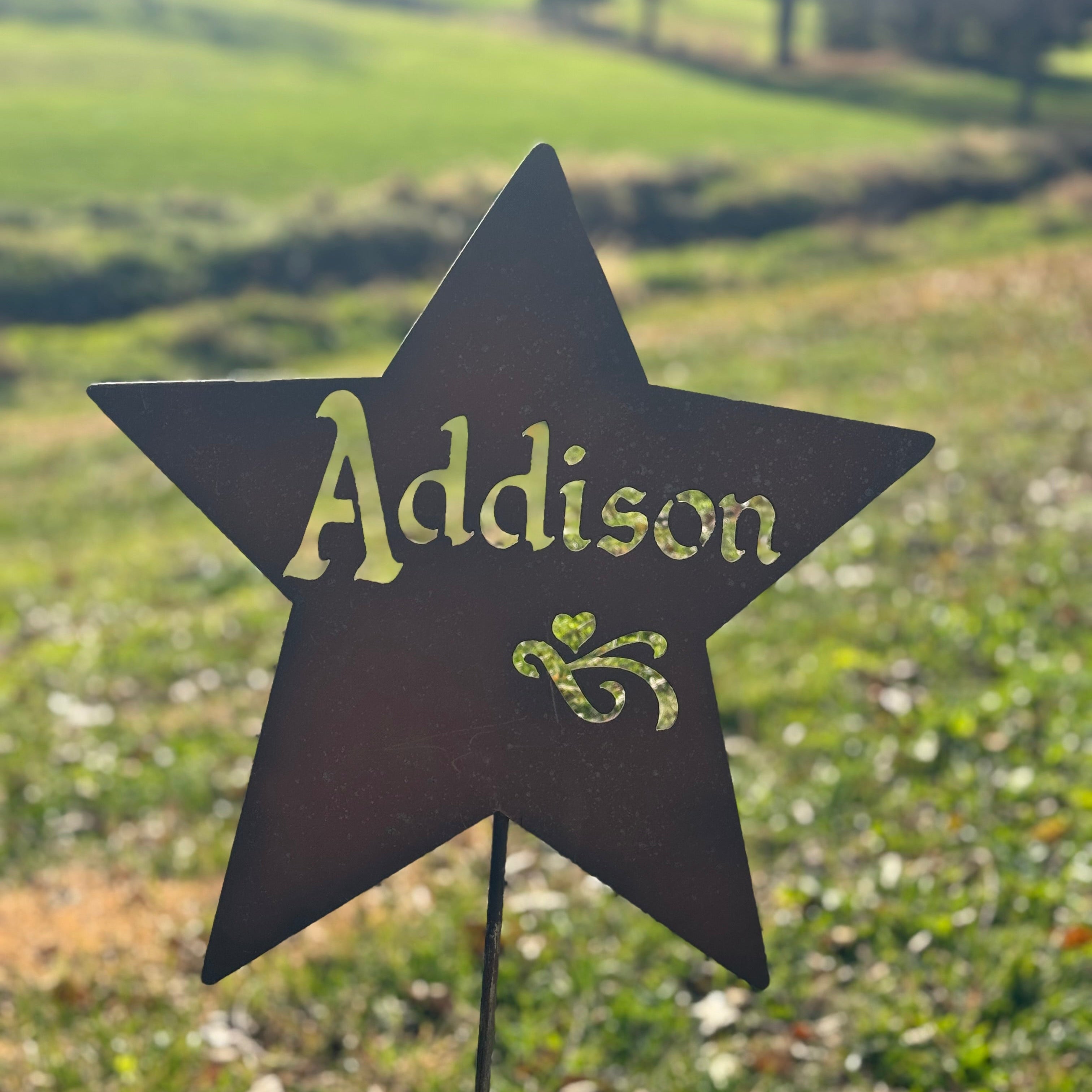 Star-shaped sign with 'Addison' on a grassy field