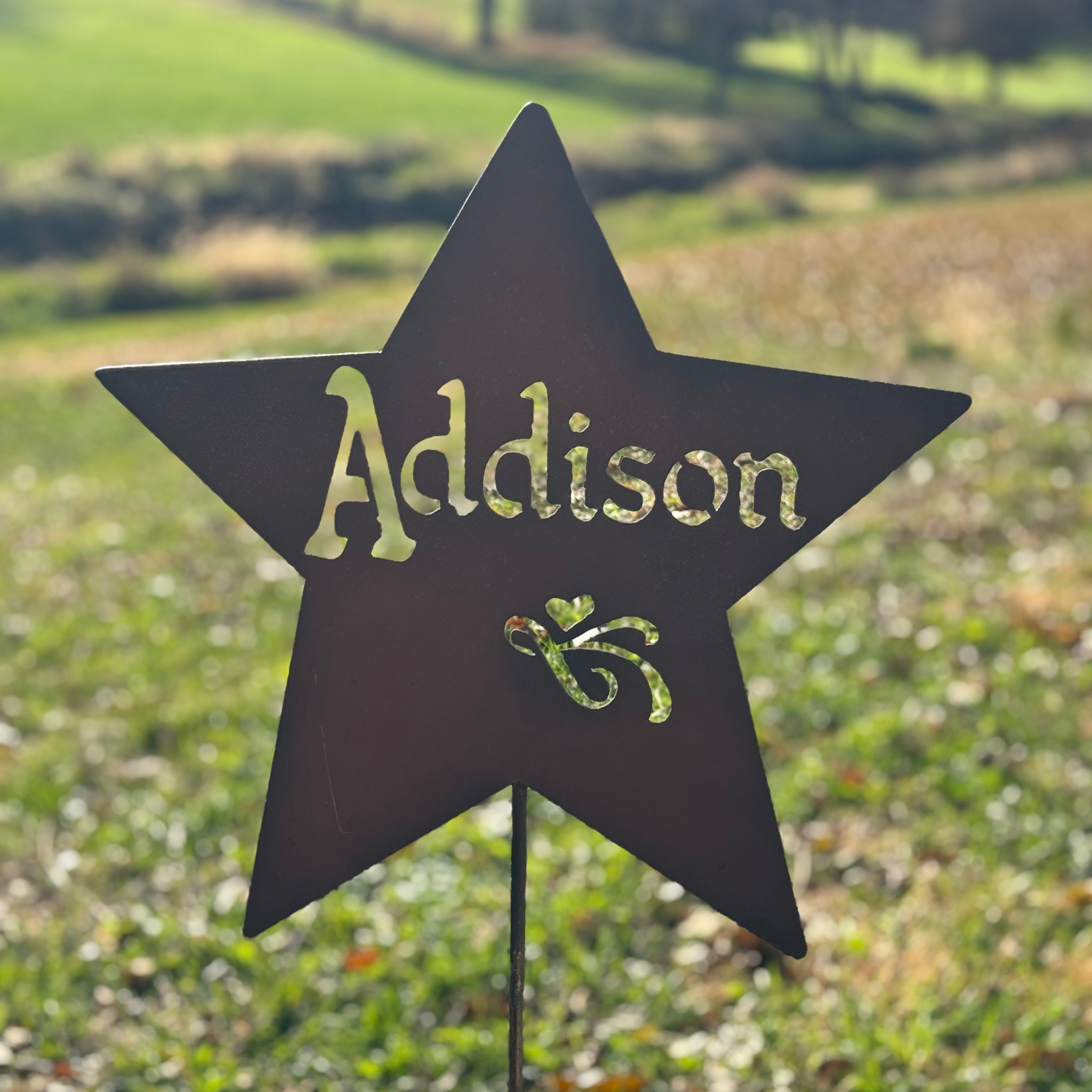 Star-shaped sign with 'Addison' on a grassy field