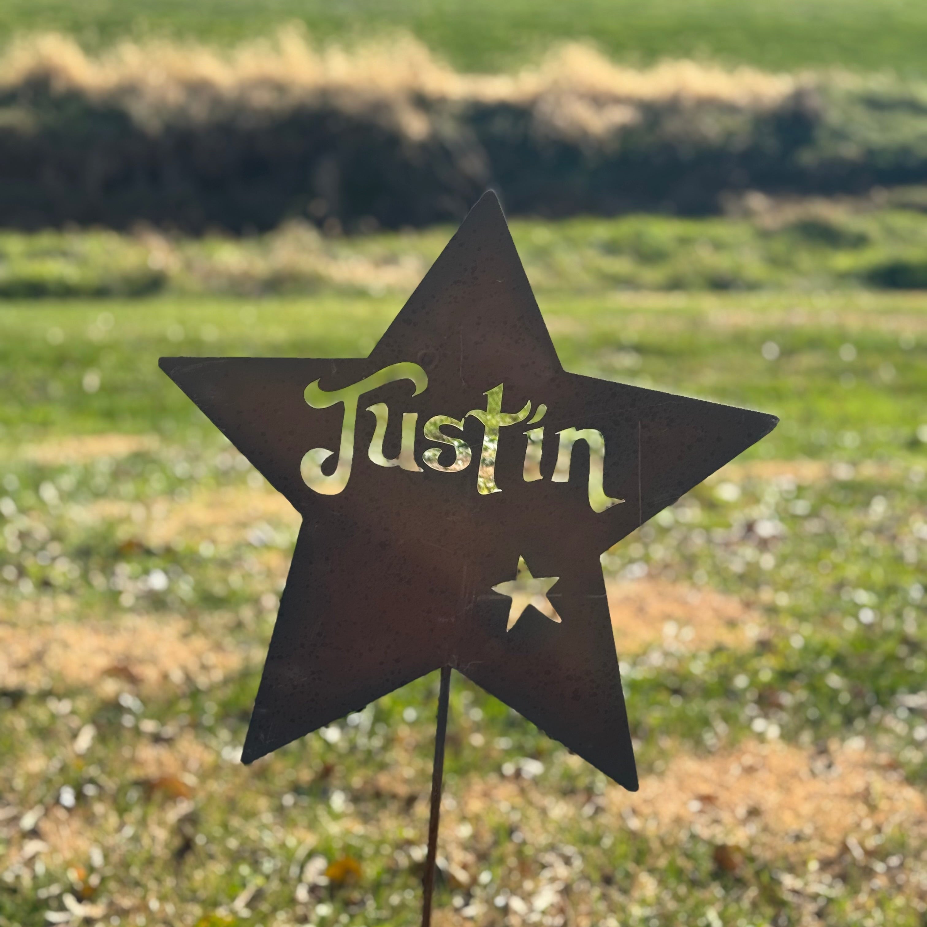 Star-shaped sign with 'Justin' on a grassy background