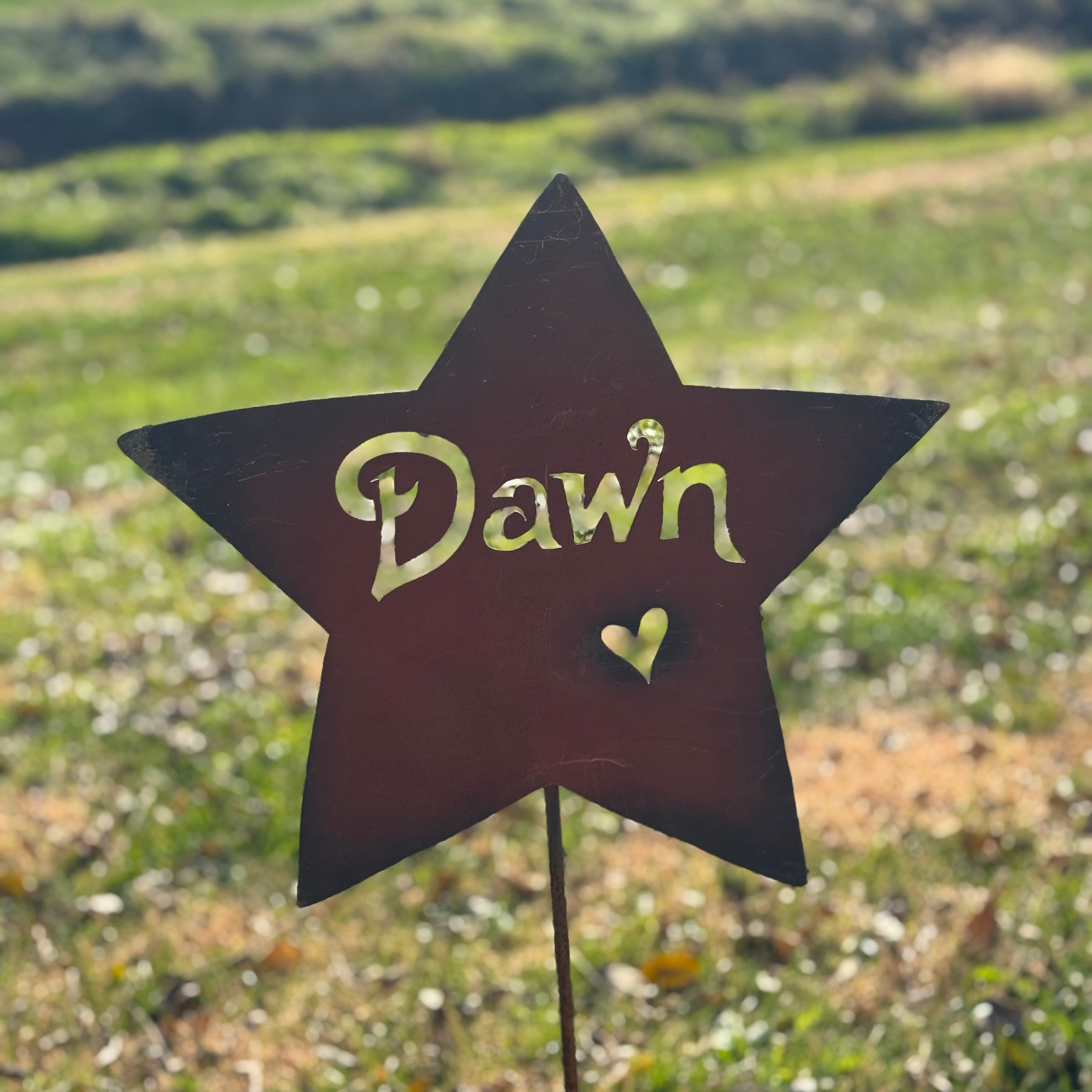 Star-shaped sign with 'Dawn' and a heart on a grassy background