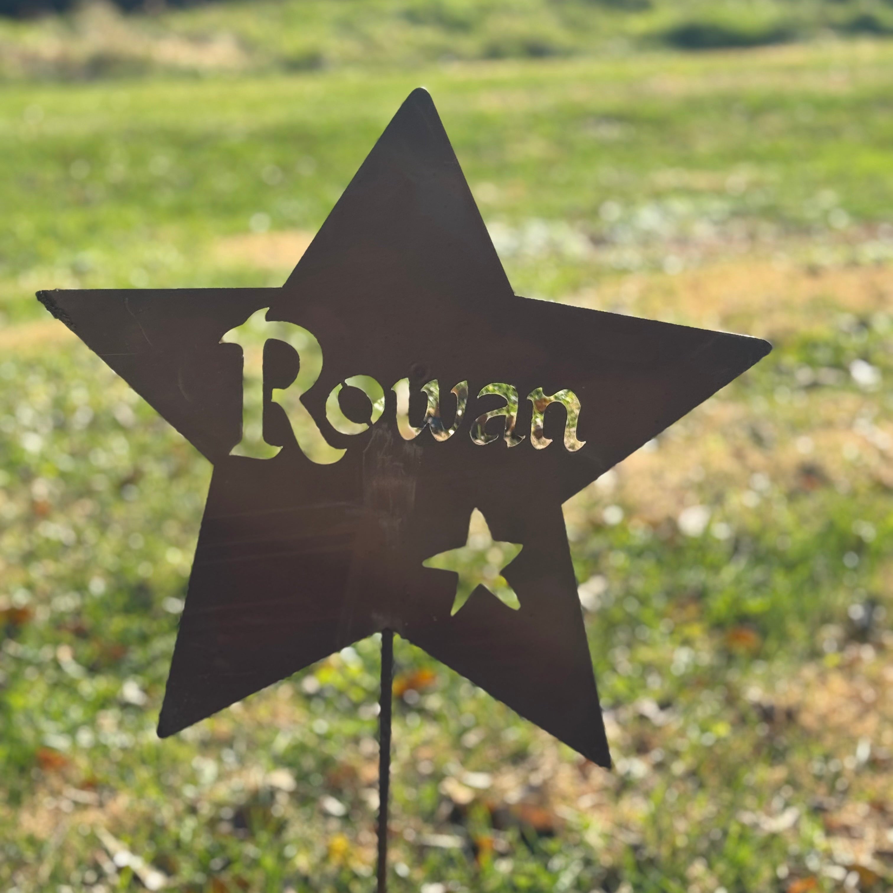 Star-shaped garden sign with 'Rowan' on a grassy background