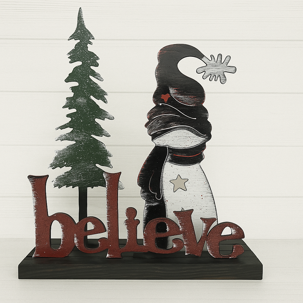 Decorative sign with a tree and snowman silhouette, featuring the word 'believe'.