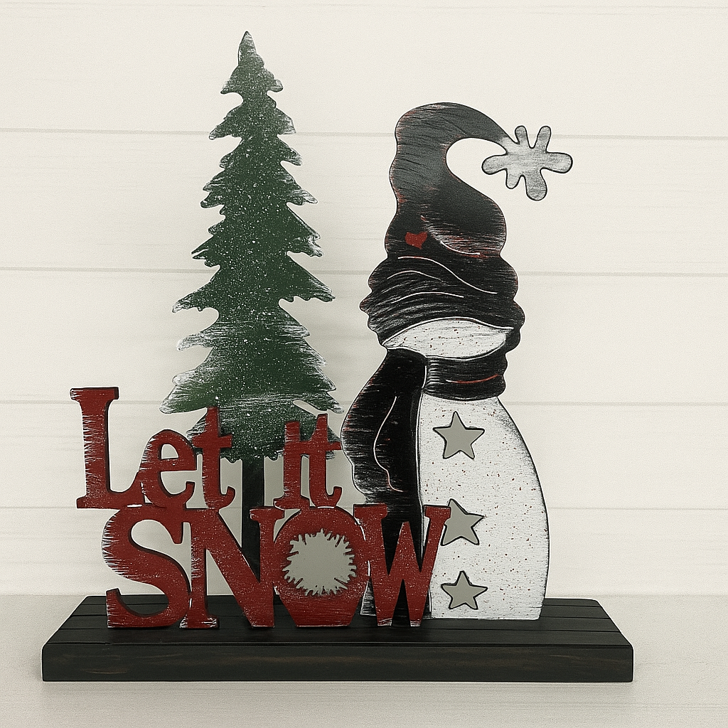Decorative sign with snowman and tree, featuring 'Let it Snow' text, on a white wooden background.